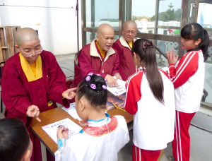 圖為蓮育上師與法師教導小學童如何結手印p1043-12-05