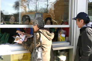 溫哥華華光功德會義工在日本公園派送熱食給街頭遊民，圖為遊民排隊領取熱食p1046-13-05C