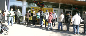 溫哥華華光功德會義工在日本公園派送熱食給街頭遊民，圖為遊民排隊領取熱食p1046-13-06