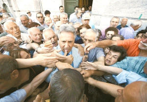 一名希臘銀行職員日前在雅典發放領取養老金的號碼牌，被大批銀髮族包圍。p1063-a4-08a