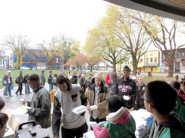 圖為在溫哥華日本公園，遊民領取華光功德會的熱食餐盒p1081-13-07