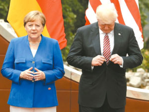 出席七大工業國高峰會的領袖準備拍攝大合照時，美國總統川普低頭整理西裝，旁為德國總理梅克爾。 p1163-a4-01a