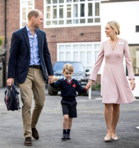 英國小王子喬治牽著父親威廉（左）與低年級主任海倫的手，一起走向接待廳。